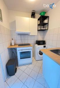 a small kitchen with a sink and a washing machine at BEGE APARTMENTS Business Studio in Hagen