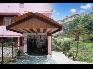 a pink house with an awning in front of it at Tara Regency Hotel in Shimla