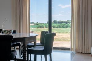 ein Esszimmer mit Tisch und Stühlen und einem Fenster in der Unterkunft Landlord bij Leuven in Holsbeek