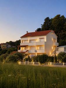 a large white building with a fence in front of it at Casa Fumica Studio in Kampor