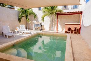 a swimming pool in a backyard with chairs and a table at Paz y Mar in Chelem