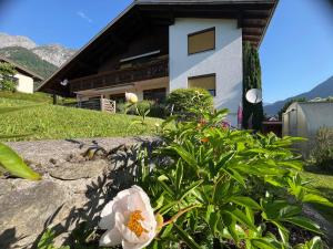 a white flower in front of a house at Ferienwohnung Glusavinahüsle in Vandans +12 photos