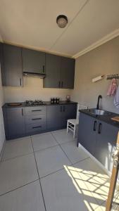 a kitchen with blue cabinets and a sink at Mminanoko Eco Guesthouse in Mamphokgo