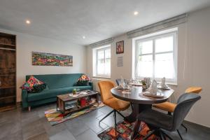 a living room with a green couch and a table at A9 City Boardinghouse ,WiFi , Parking, VAT Invoice in Günzburg
