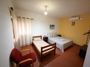 a hotel room with two beds and a chair at Stress Zero in Lopes
