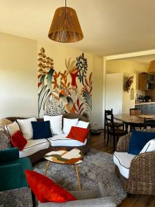 a living room with a couch and a table at Ecrin de Verdure Spa, Piscine et Nature in Angrie
