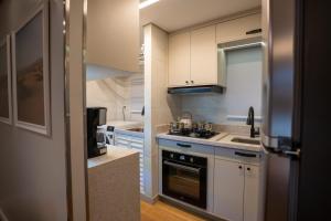 a kitchen with white cabinets and a stove top oven at Studio Nubia centro in Toledo