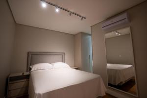 a bedroom with a white bed and a mirror at Studio Nubia centro in Toledo