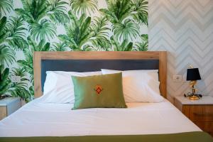 a bedroom with a white bed with a green pillow at N'Log N'Skuraj Hotel in Ferr -Skuraj +93 photos