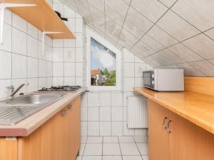 a white kitchen with a sink and a window at Martina in Stegna
