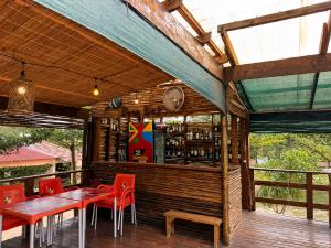 a restaurant with red tables and chairs on a wooden deck at Stress Zero in Lopes