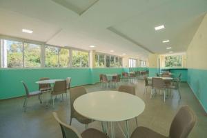 an empty classroom with tables and chairs and windows at Edifício Forte dos Lagos in Toledo