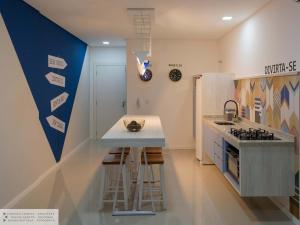 a kitchen with a counter and a refrigerator at Apartamento Geomundi proximo do lago e Shopping in Toledo