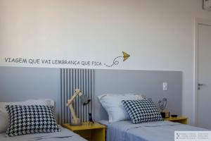 a bedroom with two beds and a sign on the wall at Apartamento Geomundi proximo do lago e Shopping in Toledo