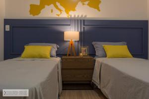 a bedroom with two beds and a blue headboard at Apartamento Geomundi proximo do lago e Shopping in Toledo +27 photos
