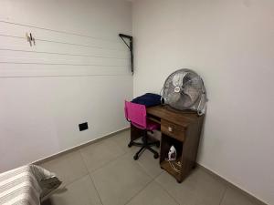 a room with a desk with a fan and a chair at Ape do lado do ginasio lago faculdades e mercados in Toledo