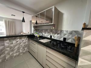 a kitchen with a black counter top and stainless steel appliances at Ape do lado do ginasio lago faculdades e mercados in Toledo