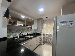 a kitchen with a sink and a refrigerator at Ape do lado do ginasio lago faculdades e mercados in Toledo +7 photos