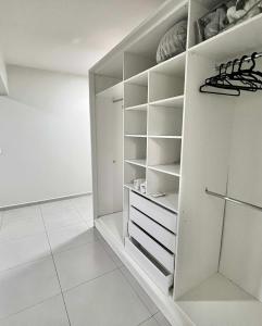 a white walk in closet with white shelves at Edifício Madrid | Ayrton Senna in Toledo