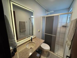 a bathroom with a toilet and a sink and a shower at Studio UNI 15 - Unipar, Lago e Shopping in Toledo