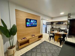 a living room with a table and a television on a wall at Studio UNI 25 - Unipar, Lago e Shopping in Toledo