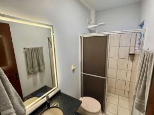 a bathroom with a shower and a toilet and a sink at Studio UNI 25 - Unipar, Lago e Shopping in Toledo