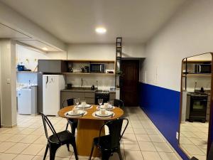 a kitchen with a wooden table and chairs in a room at Studio UNI 25 - Unipar, Lago e Shopping in Toledo