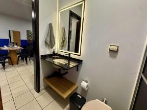 a bathroom with a sink and a mirror and a table at Studio UNI 25 - Unipar, Lago e Shopping in Toledo
