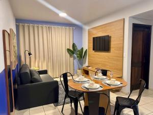a living room with a table and a couch at Studio UNI 25 - Unipar, Lago e Shopping in Toledo +12 photos