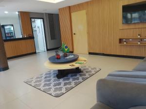a living room with a table and a couch at Tulipa Hotel in Foz do Iguaçu