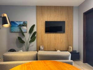 a living room with a couch and a flat screen tv at Studio UNI 102 - Unipar, Lago e Shopping in Toledo