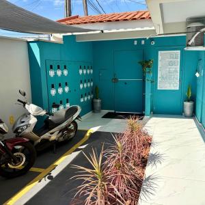 a motorcycle parked in front of a building with blue walls at Studio UNI 102 - Unipar, Lago e Shopping in Toledo