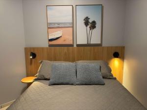 a bedroom with a bed with three pictures on the wall at Studio UNI 102 - Unipar, Lago e Shopping in Toledo