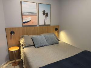 a bedroom with a bed with three pictures on the wall at Studio UNI 102 - Unipar, Lago e Shopping in Toledo