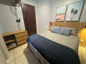 a bedroom with a bed with blue pillows on it at Studio UNI 102 - Unipar, Lago e Shopping in Toledo +30 photos