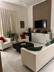 a living room with white furniture and a tv at TIZIANA'S HOUSE in Salerno