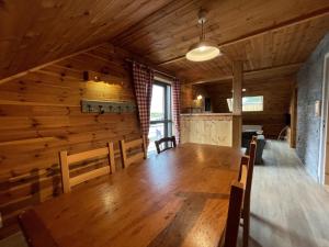 a dining room with a wooden table and chairs at Appartement le bouc in Albepierre-Bredons