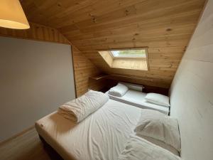 two beds in a small room with a window at Appartement le bouc in Albepierre-Bredons