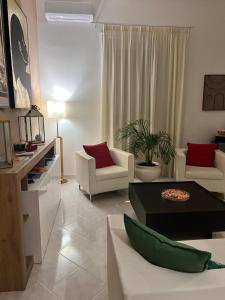 a living room with white furniture and red pillows at TIZIANA'S HOUSE in Salerno