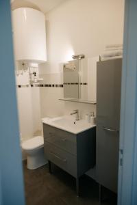 a white bathroom with a sink and a toilet at Studio élégant, central, pour 2 personnes in Pornic