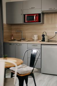 a kitchen with a table and a microwave above it at Studio élégant, central, pour 2 personnes in Pornic +5 photos