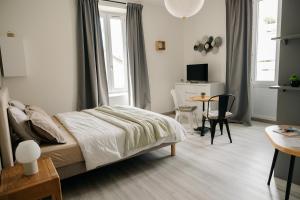 a bedroom with a bed and a desk and a table at Studio élégant, central, pour 2 personnes in Pornic