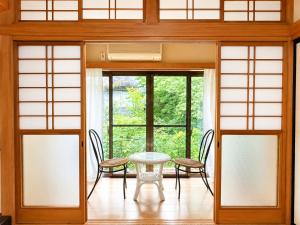 a room with a table and chairs and a window at STAY FUJI b in Yamanakako