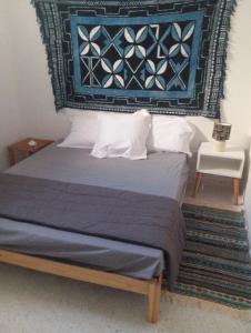 a bedroom with a bed with a blue rug on the wall at DAR Essaad in Wadhraf