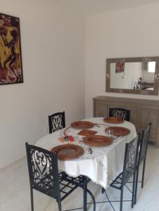 a room with a table with chairs and a mirror at DAR Essaad in Wadhraf +3 photos