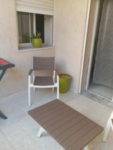 a white chair sitting on a porch next to a window at DAR Essaad in Wadhraf