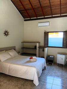 a bedroom with a bed and a flat screen tv at Pousada Aquarela de Itaunas in Conceição da Barra