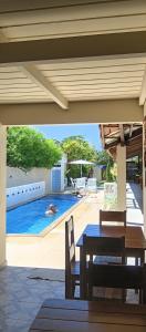 a patio with a table and a swimming pool at Pousada Aquarela de Itaunas in Conceição da Barra