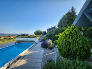 a swimming pool in a yard with bushes and trees at Lake Horizon in Balatonfüred