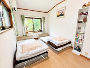 a bedroom with two beds and a book shelf at STAY FUJI b in Yamanakako